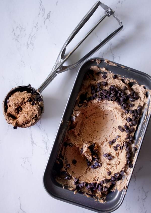 Belgian Chocolate Ice Cream at Home with the tub of ice cream and ice cream scoop beside it 