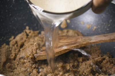 Adding boiling water to halwa