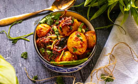 Egg Masala Dhaba Style on plate kept on a black table