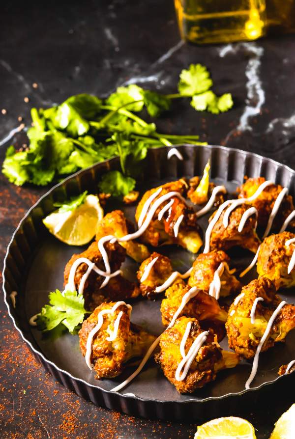 tandoori gobi in a plate with cilantro in back