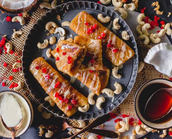 Gurer Patishapta with Coconut Filling overhead shot with cashews scattered around