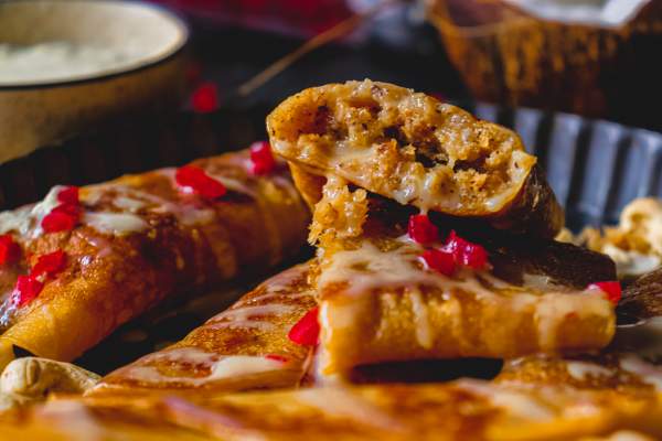 Gurer Patishapta with Coconut Filling with focus on a broken patishapta